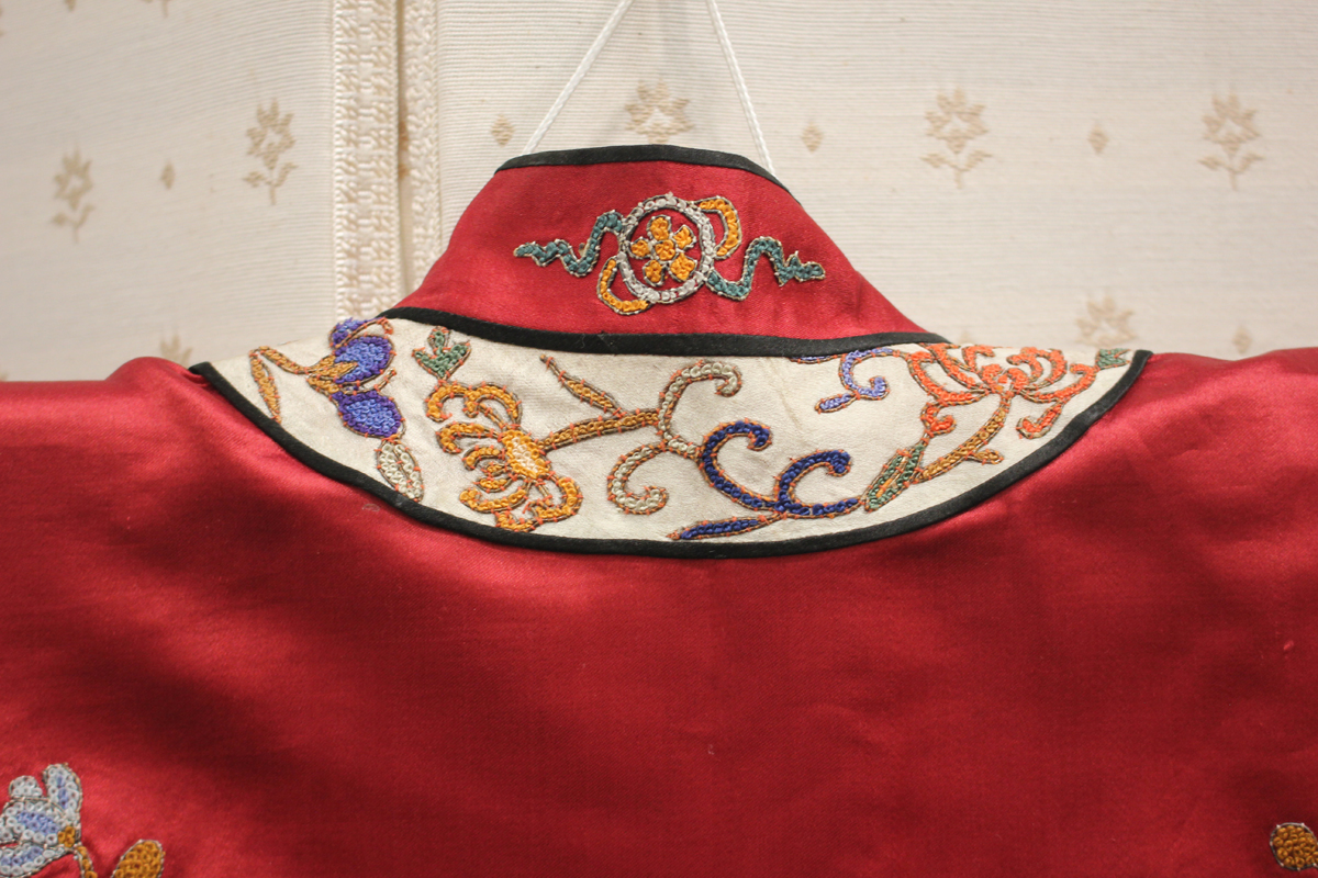 A Chinese red silk embroidered coat/robe, 20th century, worked in coloured threads with figure and - Image 6 of 19
