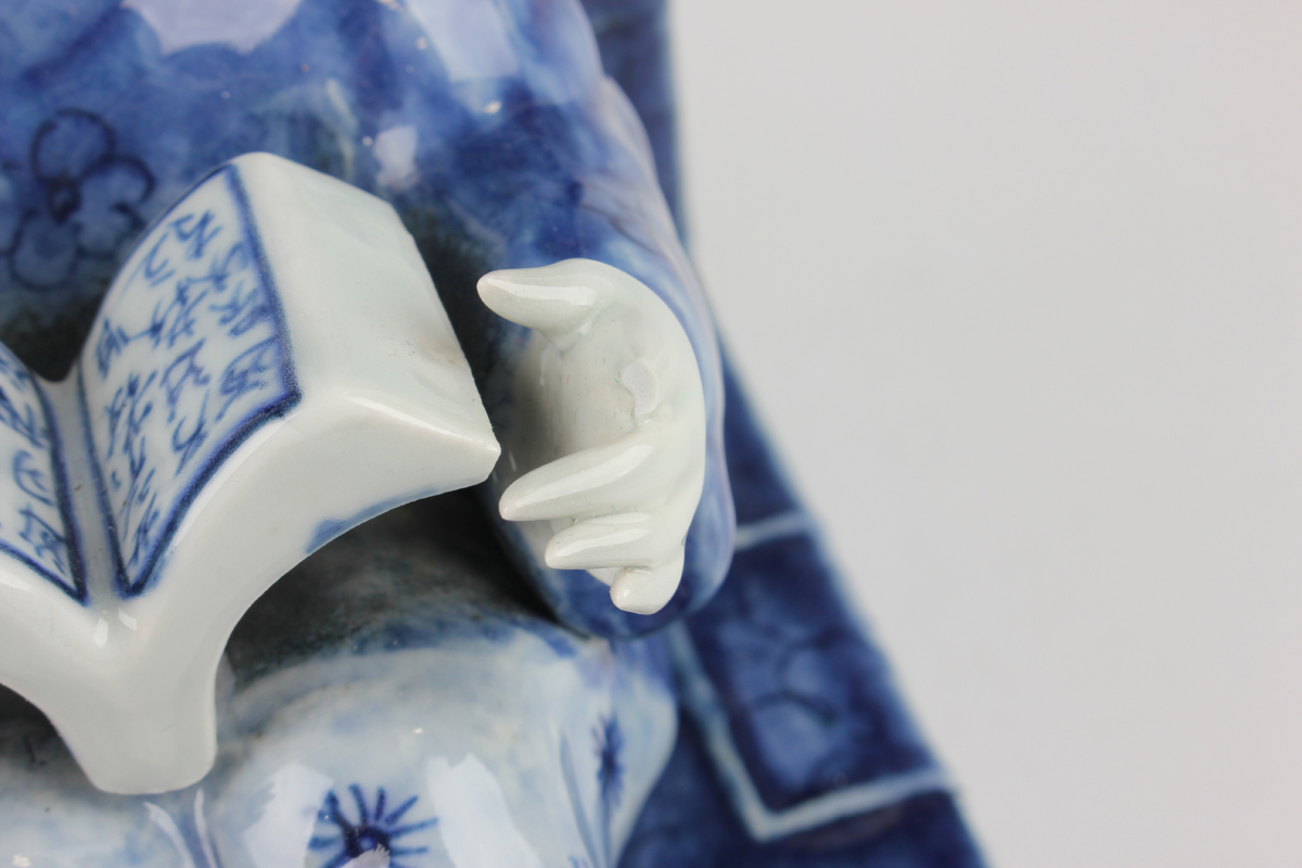 A pair of Chinese blue and white porcelain bookends, each modelled with a seated boy or girl reading - Image 13 of 18