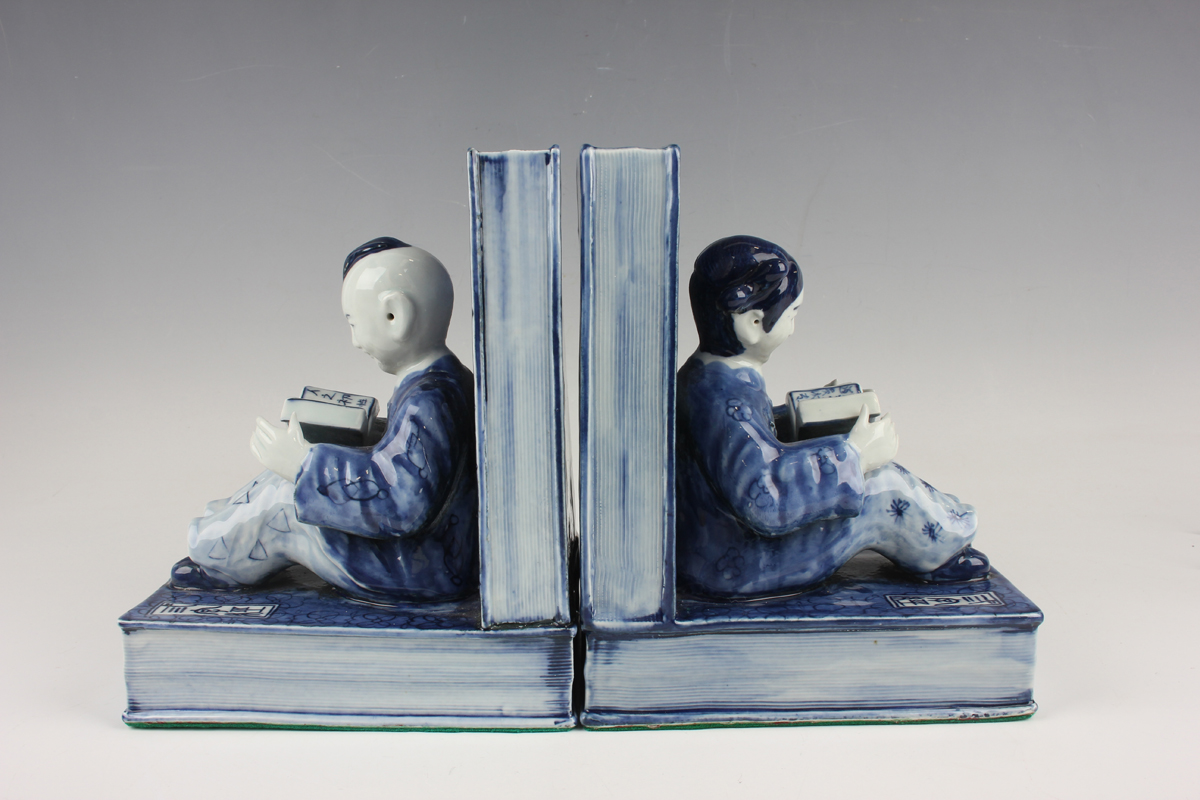 A pair of Chinese blue and white porcelain bookends, each modelled with a seated boy or girl reading - Image 2 of 18