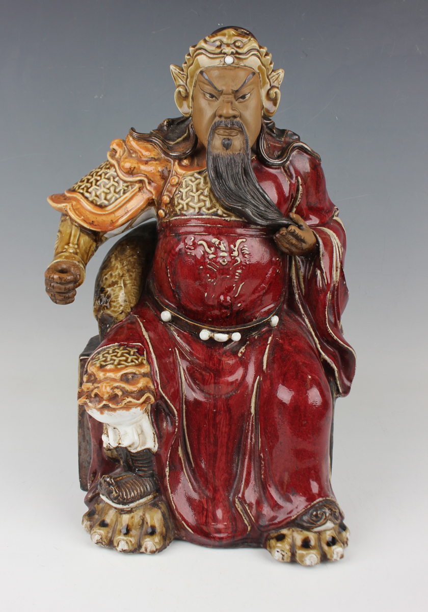A Chinese Shiwan pottery sang-de-boeuf glazed figure of Guan Yu, mid-20th century, modelled seated