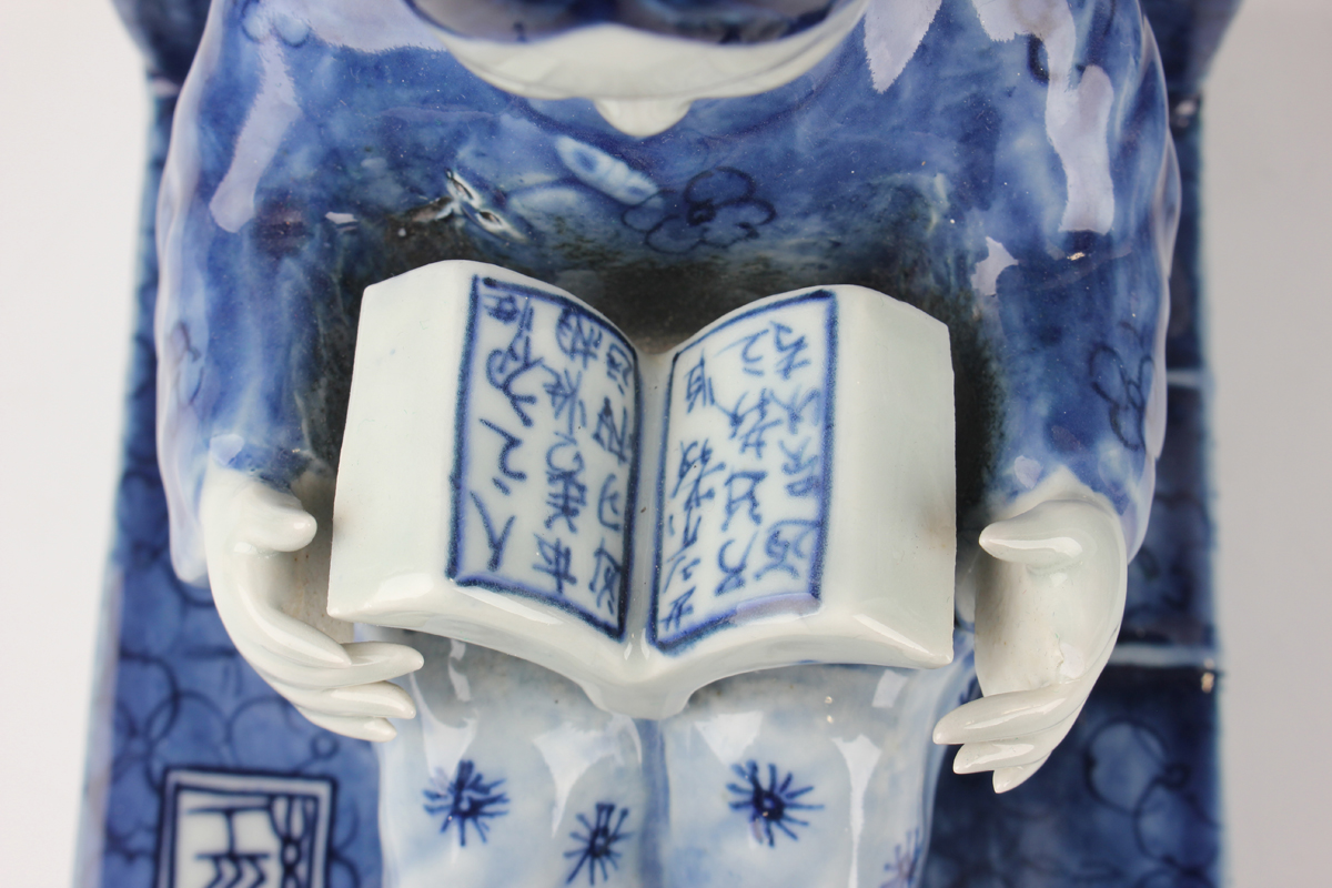 A pair of Chinese blue and white porcelain bookends, each modelled with a seated boy or girl reading - Image 12 of 18