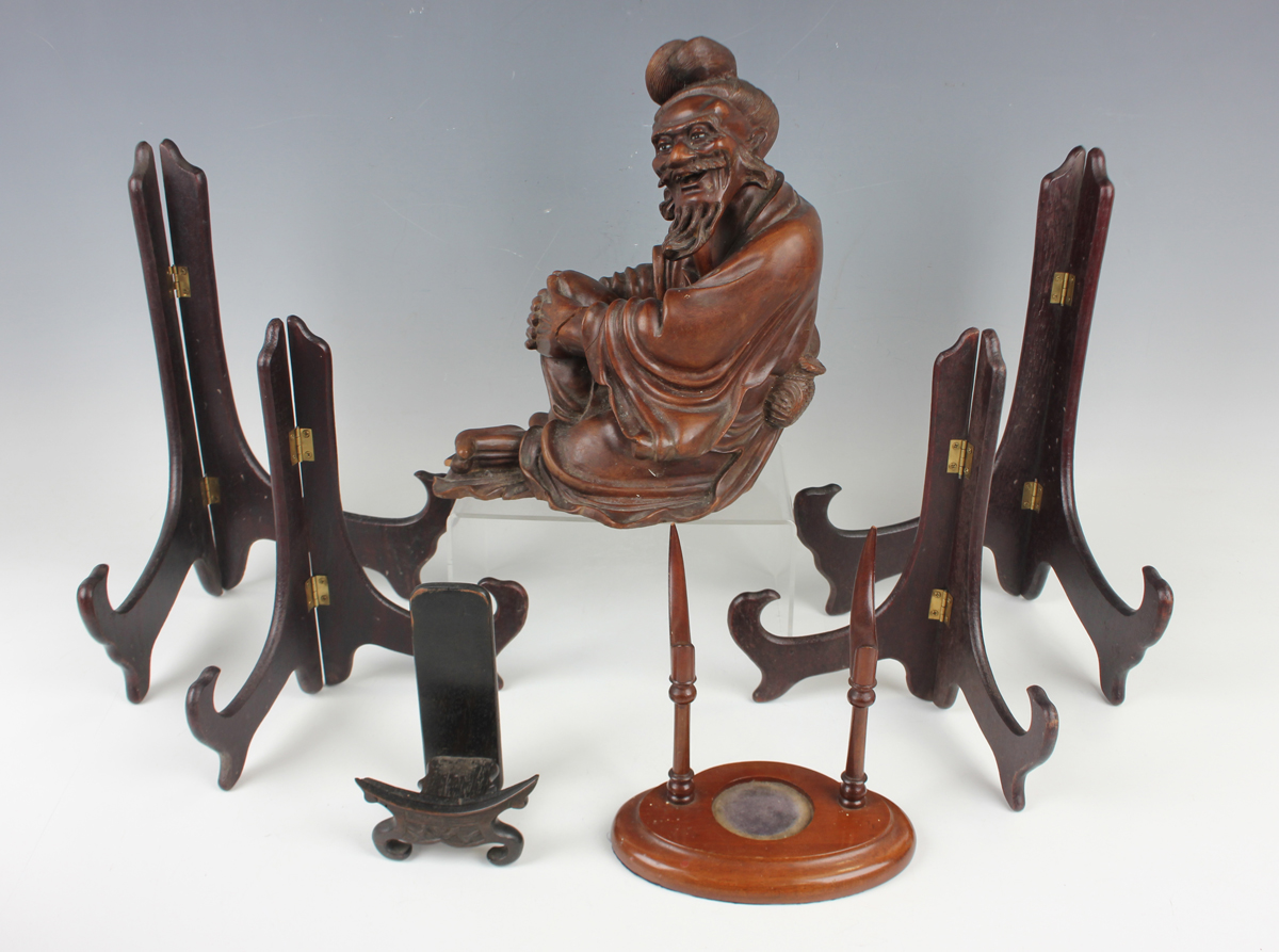 A Chinese hardwood figure of an elderly gentleman, early 20th century, modelled in a seated pose,