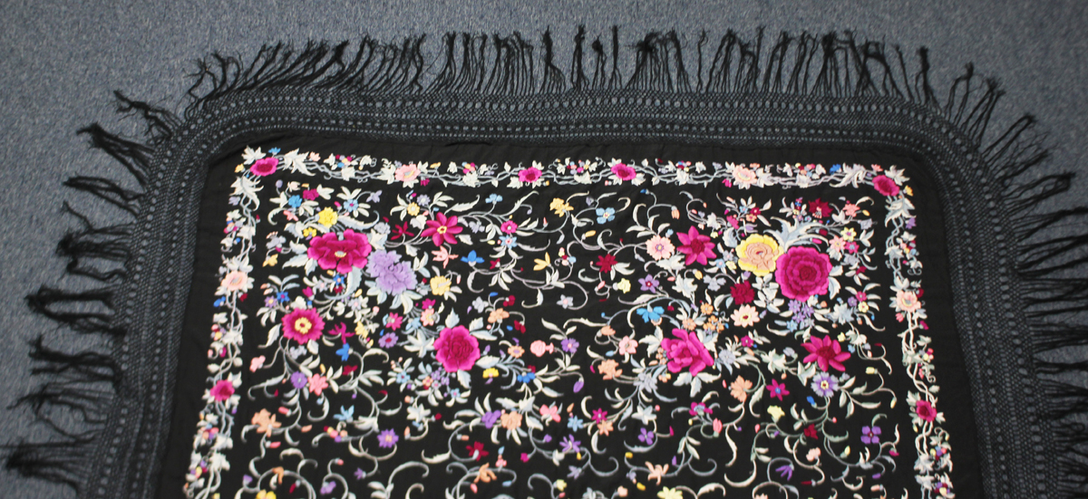 A Chinese black silk shawl, 20th century, finely worked in coloured threads with a design of