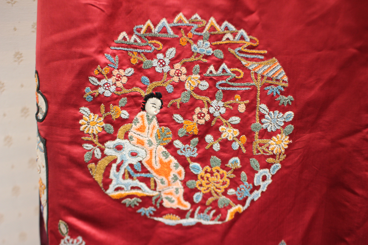 A Chinese red silk embroidered coat/robe, 20th century, worked in coloured threads with figure and - Image 8 of 19