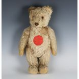 A mohair musical teddy bear with amber and black eyes and jointed body with felt pads, height 34cm.