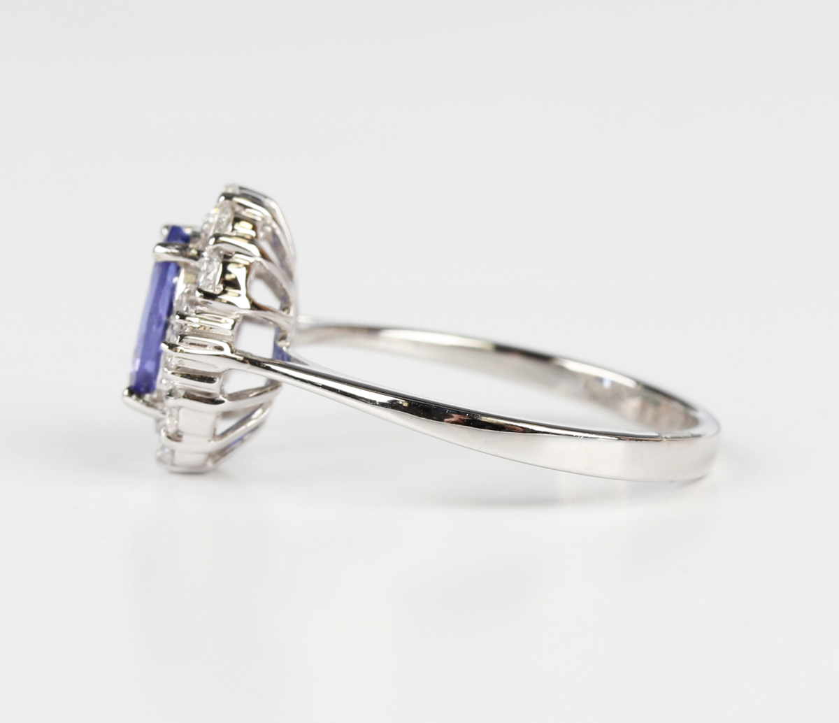 A white gold, tanzanite and diamond cluster ring, claw set with an oval cut tanzanite within a - Image 4 of 5