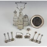 A George V silver four bottle cruet stand of 'X' shaped form with central handle, on ball feet,