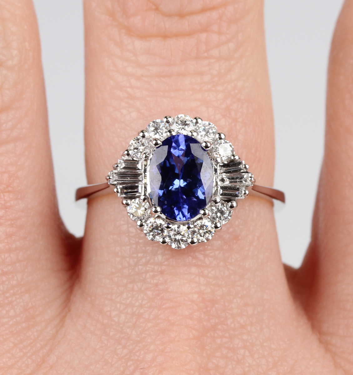 A white gold, tanzanite and diamond cluster ring, claw set with an oval cut tanzanite within a - Image 2 of 5