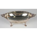 A late Victorian silver oval dish with cast bellflower rim flanked by tied ribbon handles, raised on