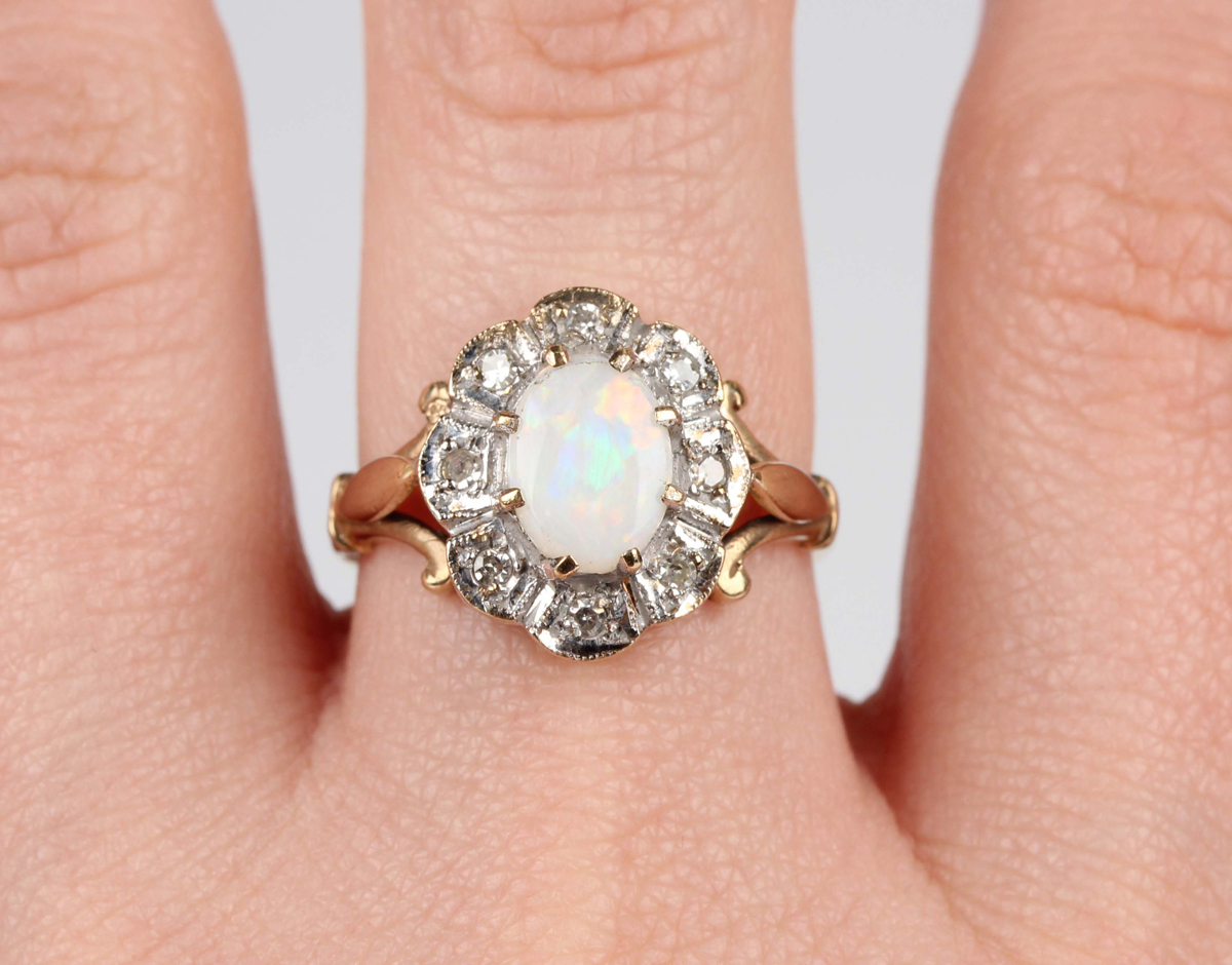 A 9ct gold, opal and diamond shaped oval cluster ring, claw set with the oval opal within a surround - Image 2 of 5