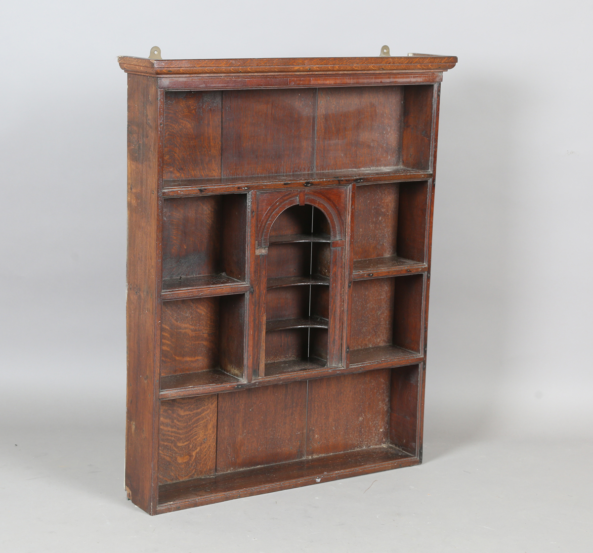 A 18th century and later provincial oak wall shelf with central arched niche, height 99cm, width