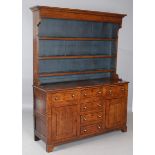 A late George III provincial oak dresser, the shelf back with blue painted backboards, the base with