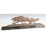 A mid-20th century brown patinated cast bronze model of a fox, raised on a black marble plinth,