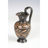 A Greek Campanian black glazed red figure oinochoe, 3rd century BC, the trefoil lipped spout above a