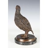 A late 20th century brown patinated bronze model of a standing grouse, raised on a circular marble