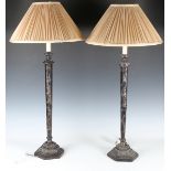 A pair of 20th century chinoiserie patinated metal table lamps, each relief cast with figures and