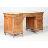 An Edwardian walnut twin pedestal desk by Gillows of Lancaster, the breakfront top inset with