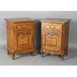 A pair of late 20th century French oak bedside cabinets, each fitted with a finely carved drawer and