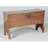 A mid-17th century oak six-plank boarded coffer, the hinged lid later incised with foliate