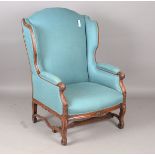 A 20th century French walnut showframe armchair of generous proportions, upholstered in blue