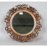 A 20th century Chinese style hardwood circular wall mirror with a carved and pierced frame, diameter