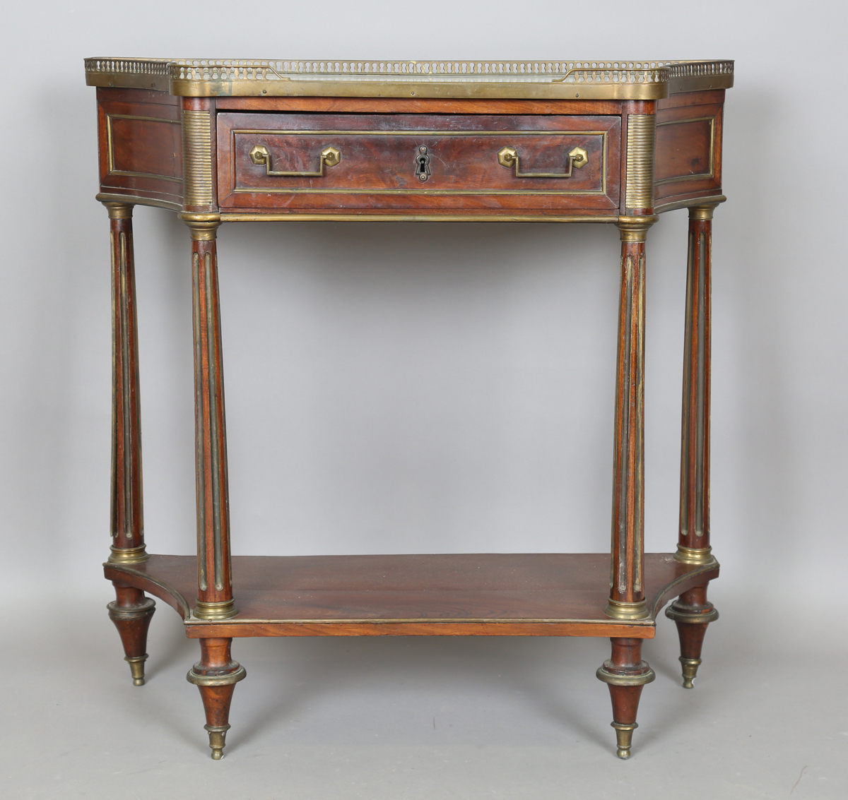 A French Empire mahogany and gilt metal mounted console table, the shaped top inset with white