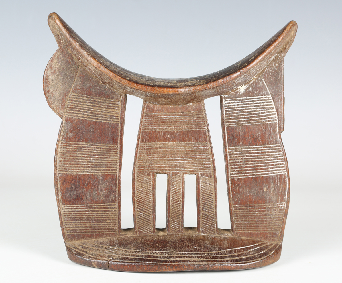 An Ethiopian carved wooden headrest, probably early 20th century, with dished top and incised line