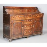 A late George III provincial oak dresser with raised gallery back above drawers and cupboards,