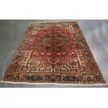 A Heriz carpet, North-west Persia, mid-20th century, the faded red field with a bold medallion,
