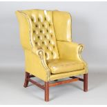 A 20th century George III style buttoned leather wing back armchair, on block legs, height 111cm,