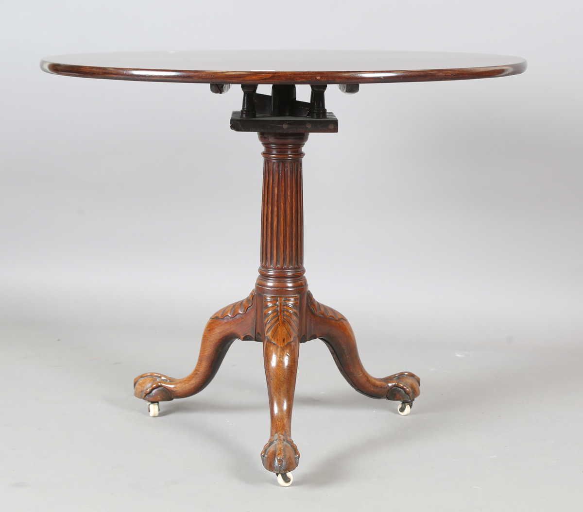 A George III mahogany tip-top supper table with later carved base, the birdcage mount above a fluted