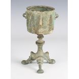A Byzantine verdigris bronze tripodal oil lamp base, height 8.5cm, together with a verdigris
