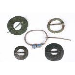 A collection of five European bronze and silver annular and ring type brooches with cast and