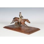 A late 19th century Austrian cold painted bronze model of a racehorse and jockey jumping a fence,