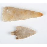 A Neolithic chipped flint arrowhead, possibly British, length 4cm, together with another Neolithic