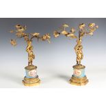 A pair of late 19th century French gilt metal three light candelabra, each with a putto support