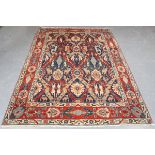 A Caucasian style carpet, mid-20th century, the midnight blue field with overall palmettes,