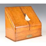 A late Victorian oak stationery box, the double-hinged sloping lid above a single drawer, height