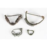 A group of four ancient Greek copper alloy fibula type brooches with applied and cast decoration,