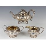 A George IV silver teapot of lobed squat circular form, decorated with repoussé flowers and scrolls,