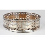 An Edwardian silver wine coaster, the side pierced and engraved with foliate roundels and garlands