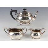 A George V silver three-piece tea set, comprising teapot, milk jug and two-handled sugar bowl,
