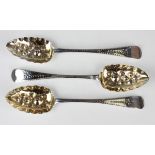 A set of three George III silver Old English pattern tablespoons, each bowl with later embossed