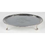 A George III silver oval teapot stand, the centre crest engraved with a shield surmounted by a