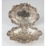 A pair of late Victorian silver sweetmeat dishes, each pierced and embossed with scrolls, flowers