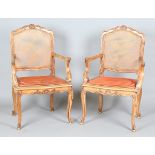 A pair of late 20th century French cherry framed elbow chairs with carved backs and cabriole legs,