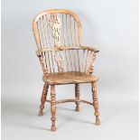 A mid-19th century yew and elm Windsor armchair with a pierced splat back and a crinoline stretcher,