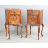 A pair of late 19th century French walnut bedside cabinets with shaped rouge marble tops above