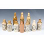 Ten early 20th century stoneware bottles, all with black printed advertising for the Dorking area,