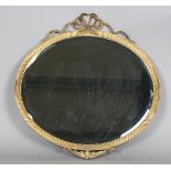 An Edwardian gilt composition oval wall mirror with a trailing ribbon surmount, 66cm x 65cm (some